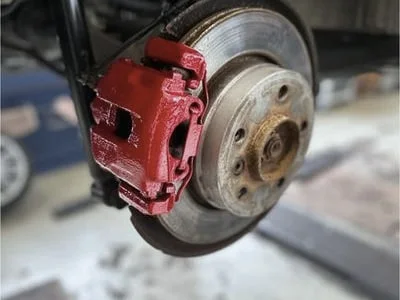 Rot lackierter Bremssattel an einer Sportbremsanlage.