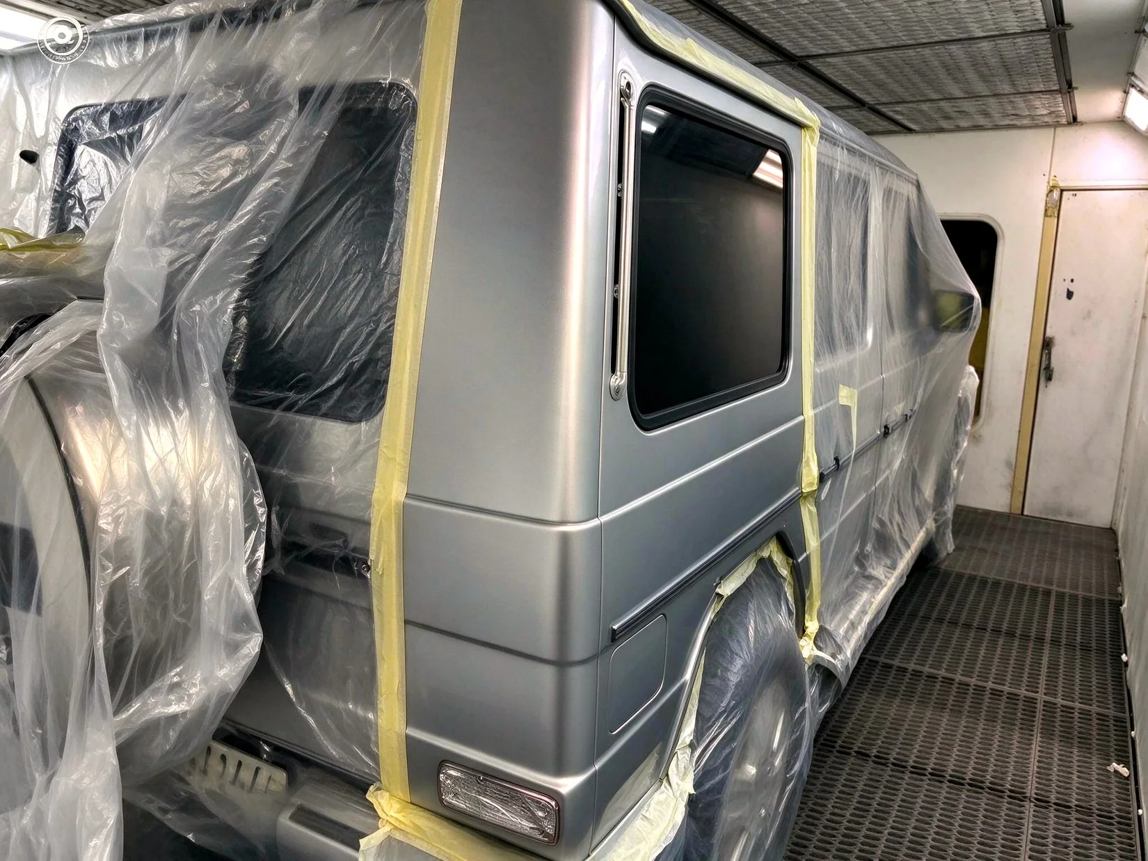 Silberne Mercedes-Benz G-Klasse in der Spritzkabine.